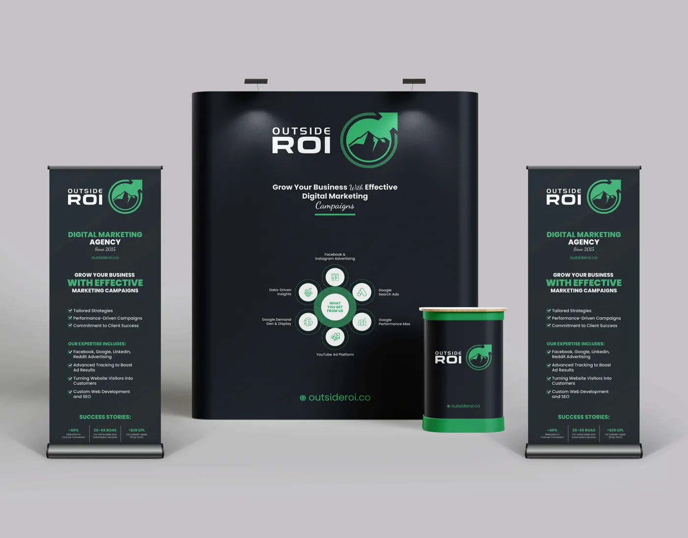 Outside ROI trade show booth with a backdrop wall, two roll-up banners and a counter in black and green